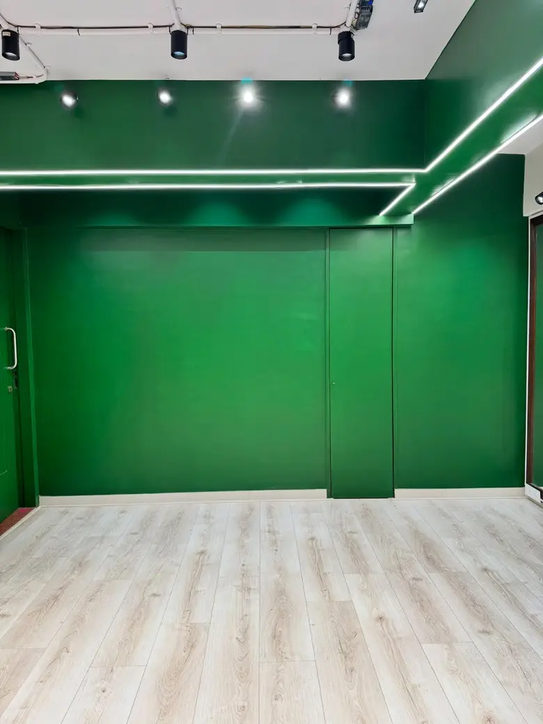 Plain deep green backdrop wall with light oak floor at P Square Studio