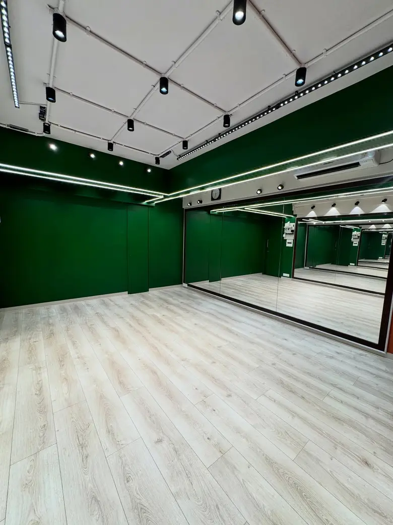 Full-height mirror wall beside a deep green wall at P Square Studio, Andheri West
